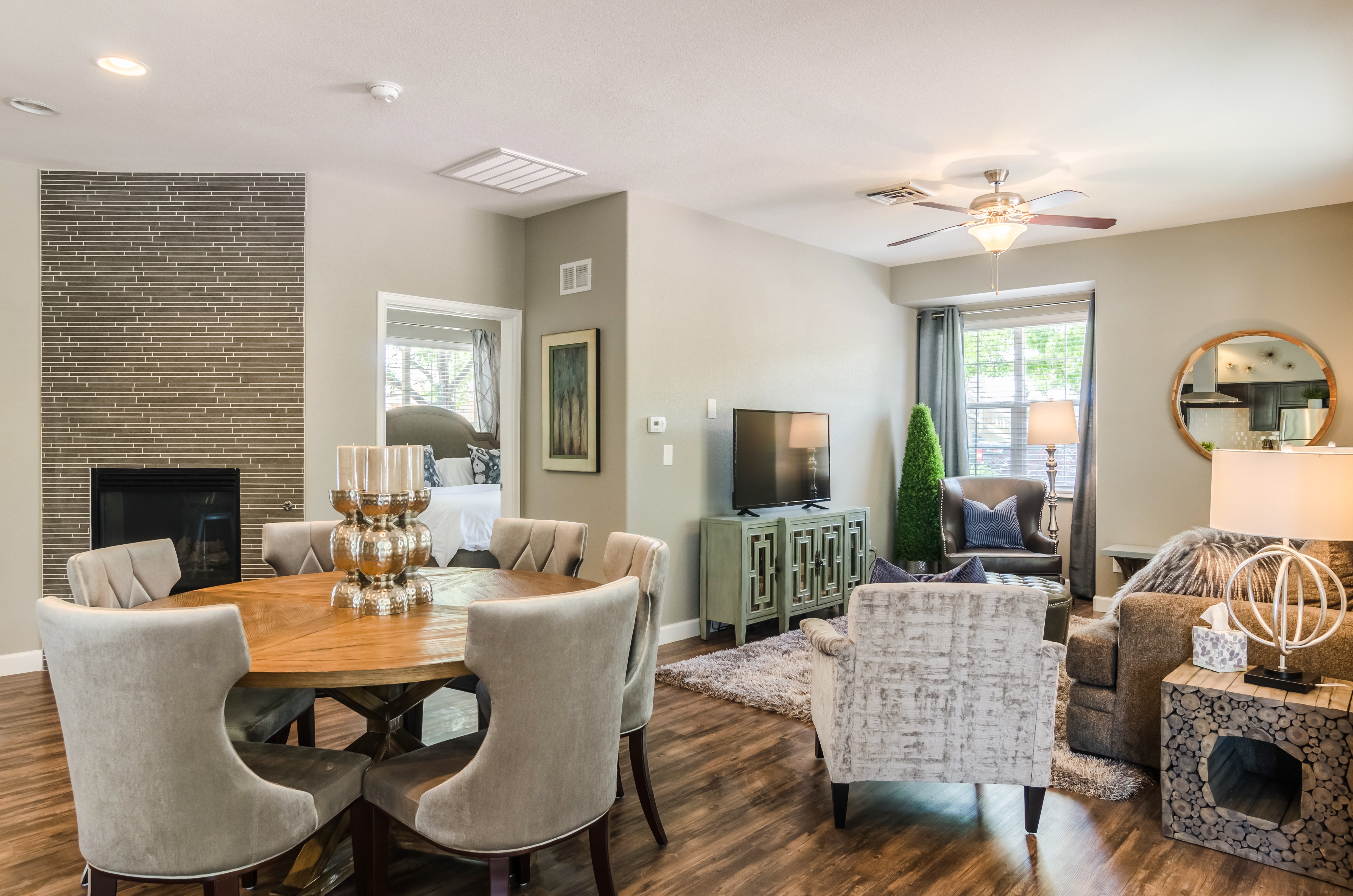 A living room with a fireplace and a dining table.